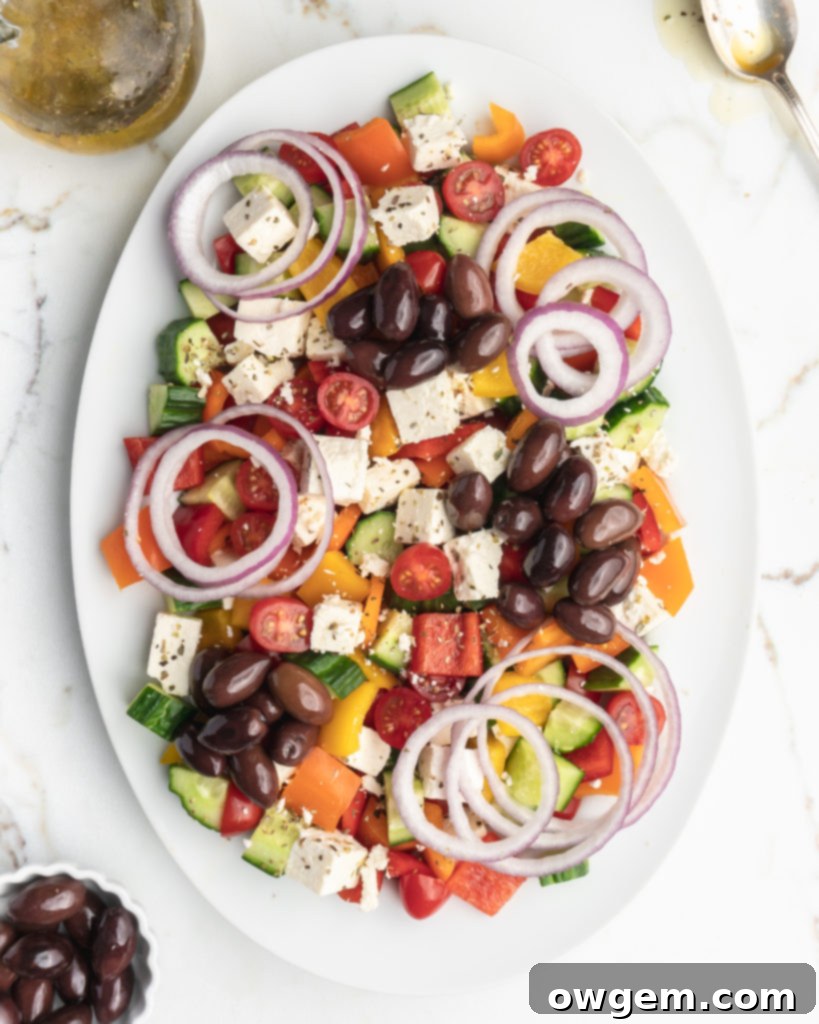 This easy greek salad features peppers, cucumbers, cherry tomatoes, Kalamata olives, feta cheese, red onions, and a homemade dressing 