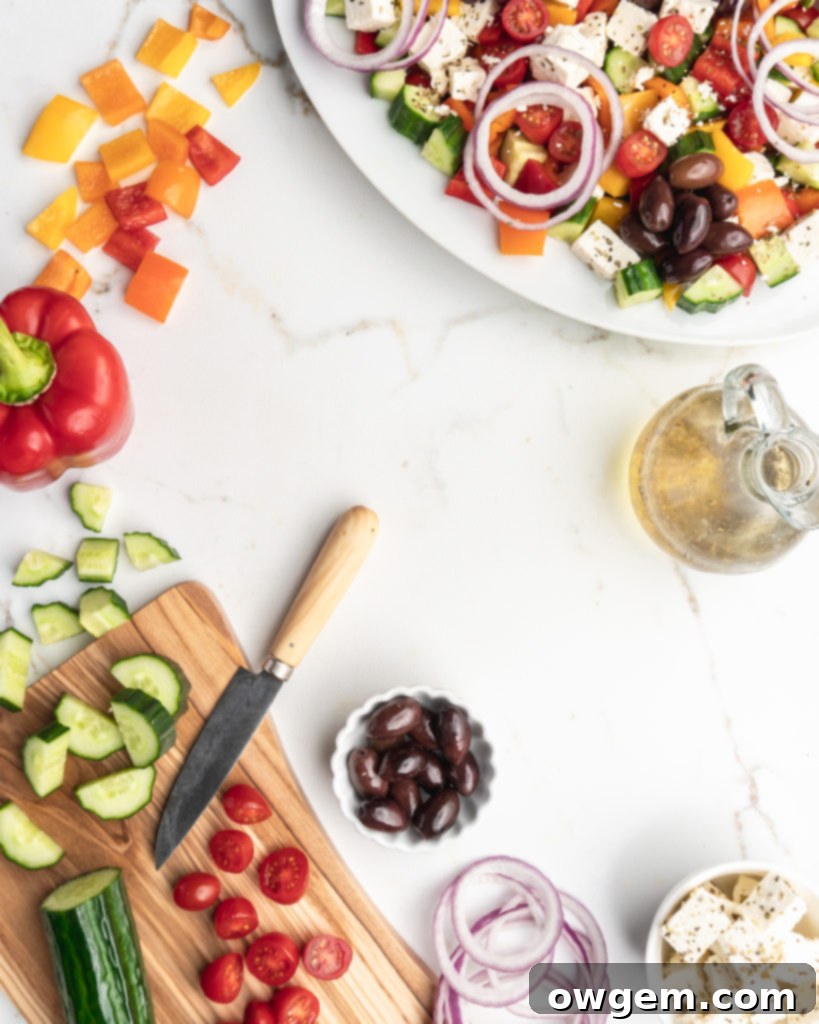 This easy greek salad features peppers, cucumbers, cherry tomatoes, Kalamata olives, feta cheese, red onions, and a homemade dressing