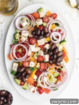 This easy greek salad features peppers, cucumbers, cherry tomatoes, Kalamata olives, feta cheese, red onions, and a homemade dressing