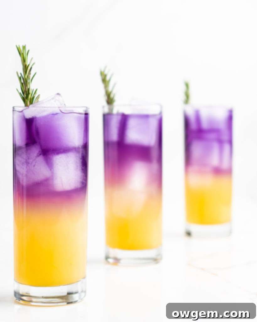 A hand pouring the purple butterfly pea flower tea and yuzu mixture over a tall cocktail glass filled with ice, vodka, sake, peach syrup, and soda water, creating a gradient effect.