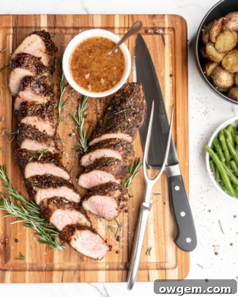 Homemade rosemary peach mustard glaze in a small bowl, with fresh rosemary sprigs and lemons.
