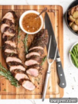 Pork tenderloin slices glazed with rosemary peach mustard sauce, garnished with fresh rosemary.