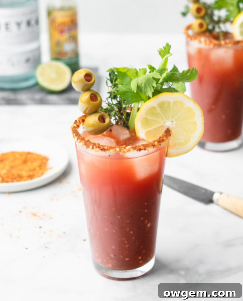 An array of Caesar garnishes including pickled green beans, olives, a lime wedge, and beef jerky.