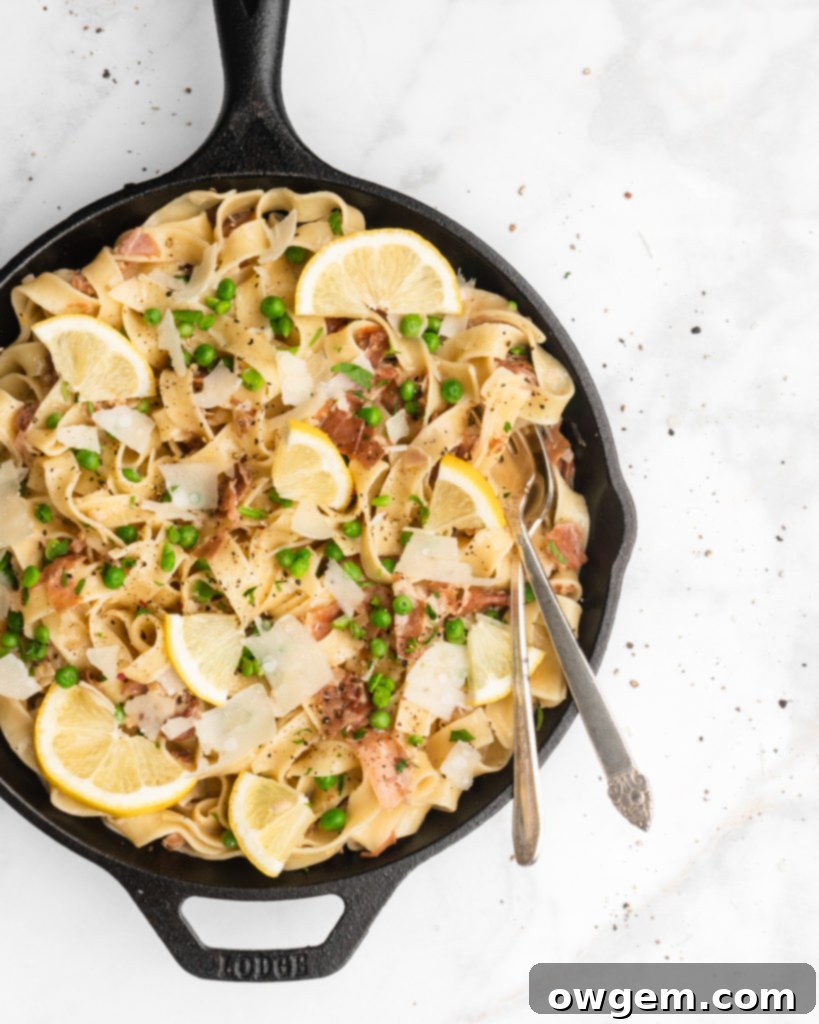 Close-up of creamy Lemon Prosciutto and Pea Fettuccine, with golden fried prosciutto, bright green peas, and fresh lemon zest coating thick fettuccine ribbons.