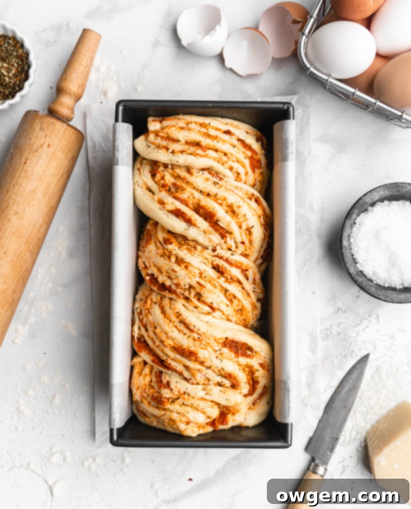 This braided Pizza bread features marinara, mozzarella, and parmesan as a filling, which is then sliced and braided into the bread to create an artistic looking bread