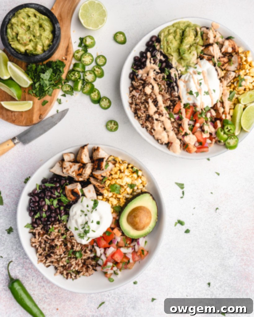 Vibrant Tequila Lime Grilled Chicken Burrito Bowl with brown rice, grilled chicken, corn, salsa, black beans, cilantro, and creamy avocado, drizzled with chipotle sauce.