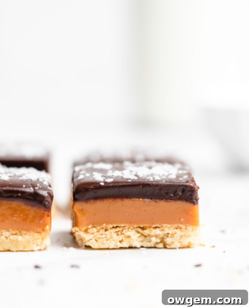 A buttery, rich shortbread layer is topped with a golden creamy caramel layer that is infused with vanilla beans an bourbon, which is further topped with a dark chocolate layer and flaky sea salt.