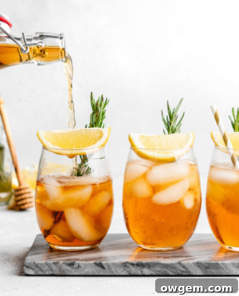 Close-up of a glass of Honey Rosemary Iced Tea, highlighting the beautiful color and fresh garnish.