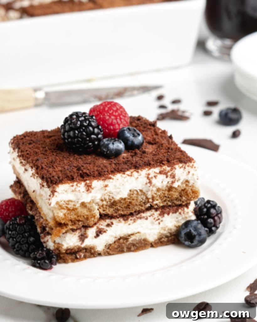 A beautifully presented slice of creamy no-bake tiramisu topped with fresh berries