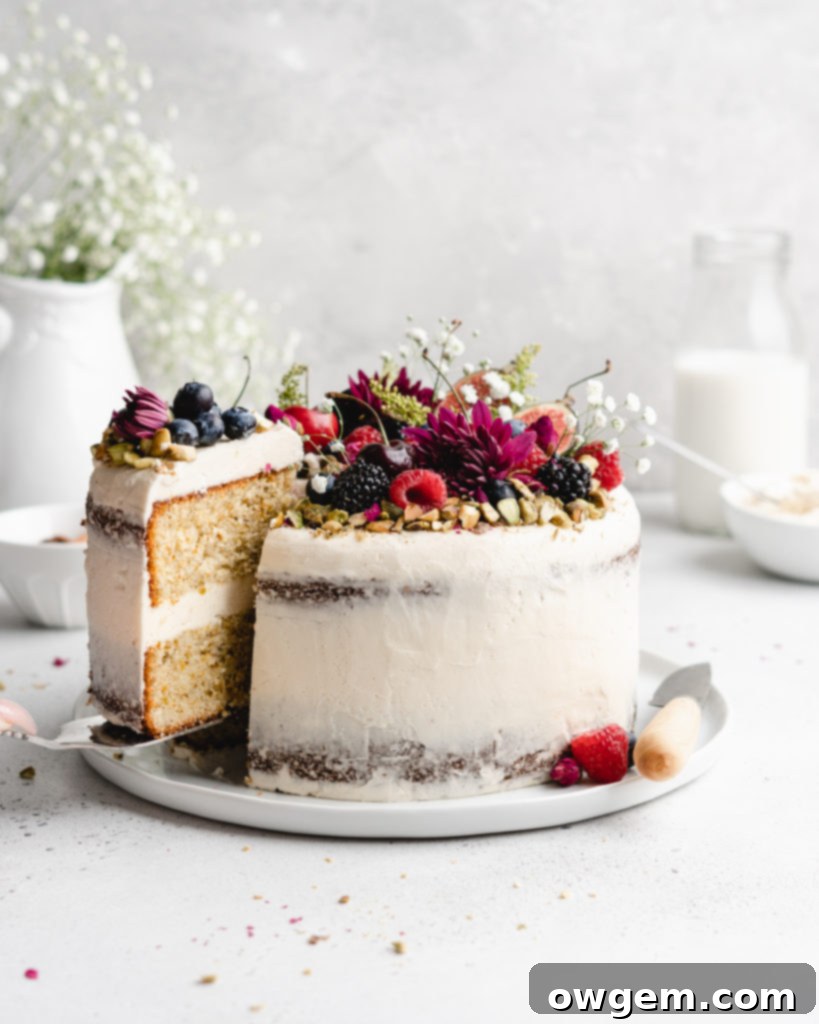 Two slices of Pistachio cake with honey rosewater swiss meringue buttercream, showcasing the semi-naked frosting
