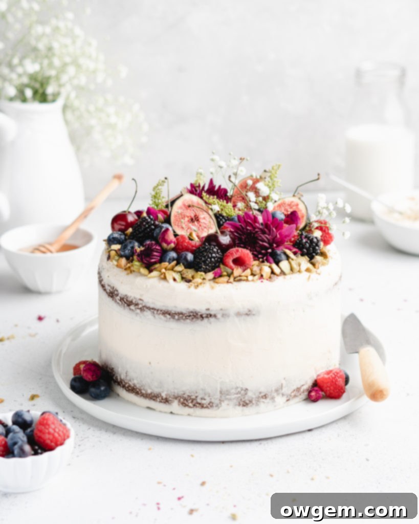 The decorated Pistachio cake with honey rosewater swiss meringue buttercream from a different angle, highlighting its vibrant garnishes