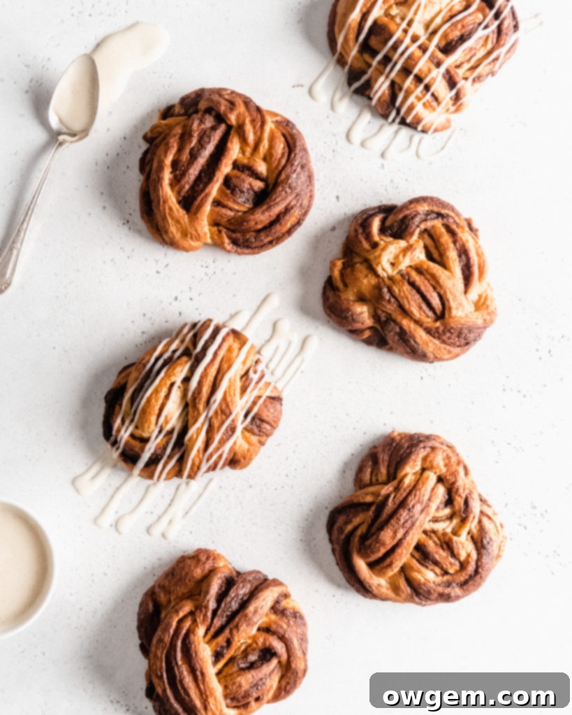 Close-up of freshly baked cinnamon brioche babka knots, golden and glistening with a sweet glaze, showing off their intricate swirls.