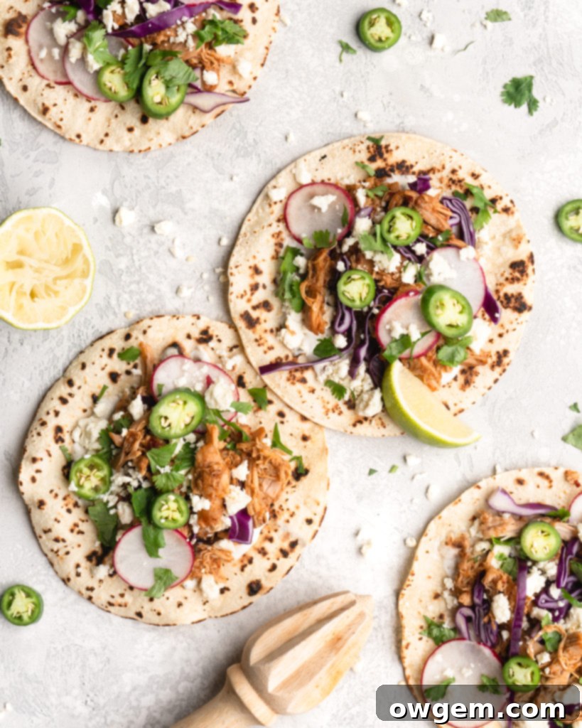 Delicious pulled chipotle chicken tacos topped with fresh cilantro and lime wedges, ready to eat.