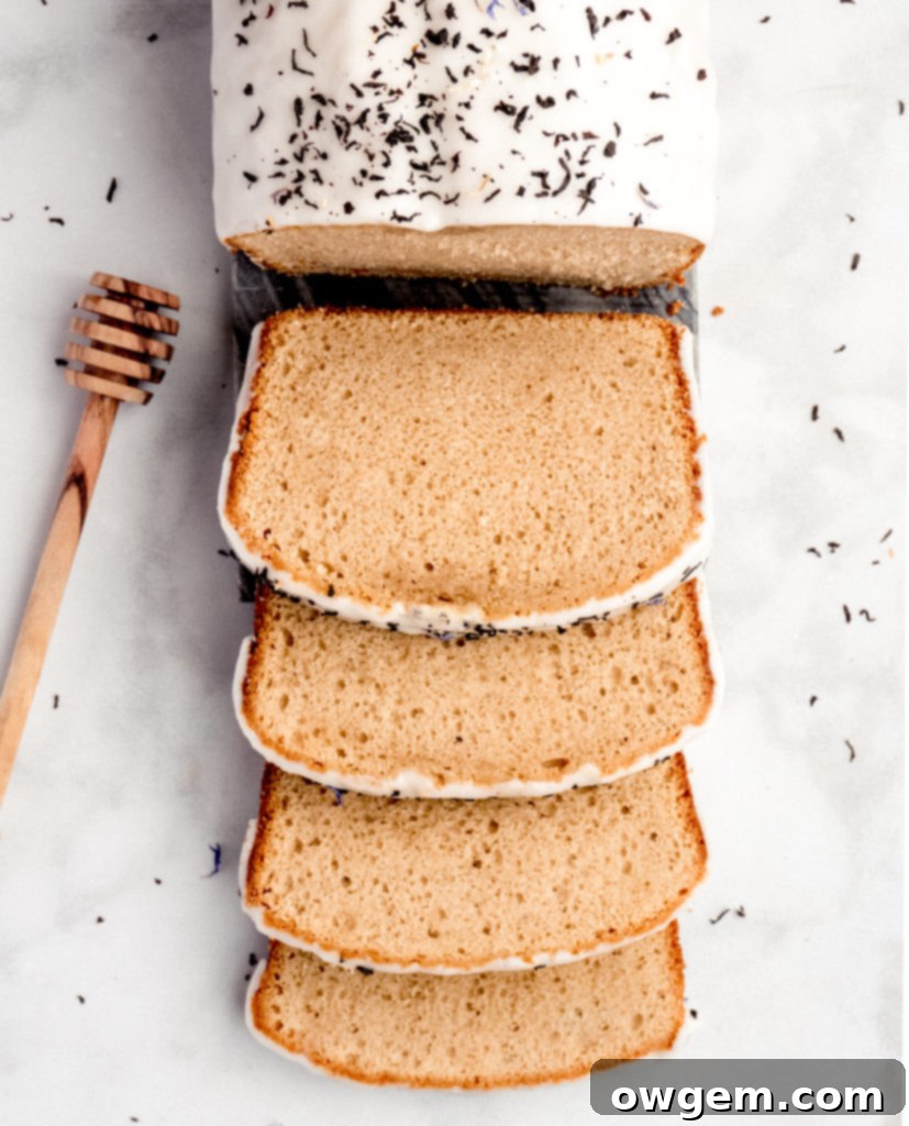 A close-up of the Earl Grey Loaf Cake with a drizzle of lemon honey glaze, highlighting its inviting texture and aroma.