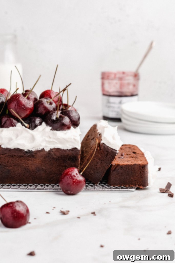 Rich chocolate loaf cake is swirled with cherry jam, then topped with fresh whipped cream and fresh cherries