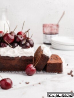 Rich chocolate loaf cake is swirled with cherry jam, then topped with fresh whipped cream and fresh cherries