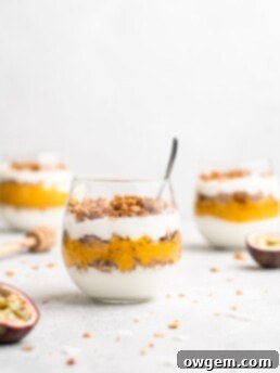Layers of passion fruit and mango puree, yogurt, and coconut granola make up with tropical yogurt parfait
