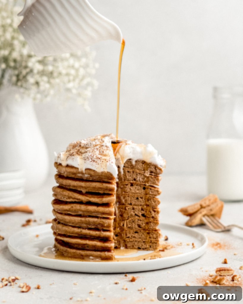Two Cinnamon Bun Pancakes on a plate with a dollop of cream cheese frosting, a delightful breakfast treat.