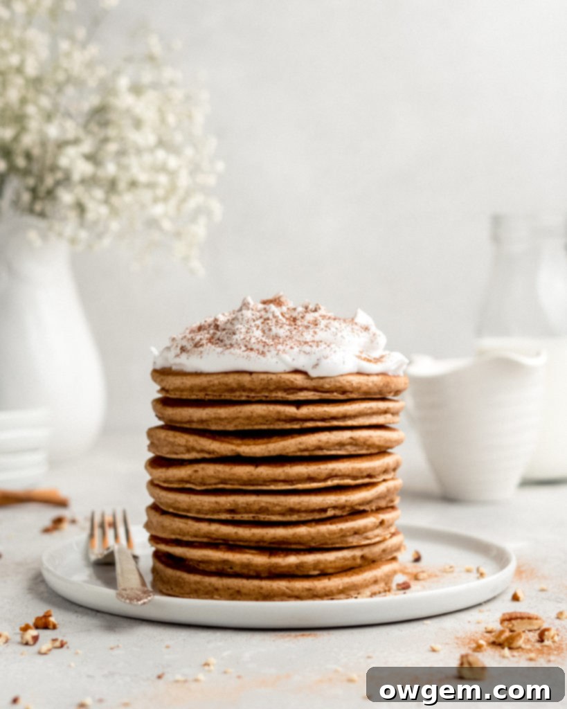 Freshly cooked Cinnamon Bun Pancakes, golden and fluffy, ready for frosting.
