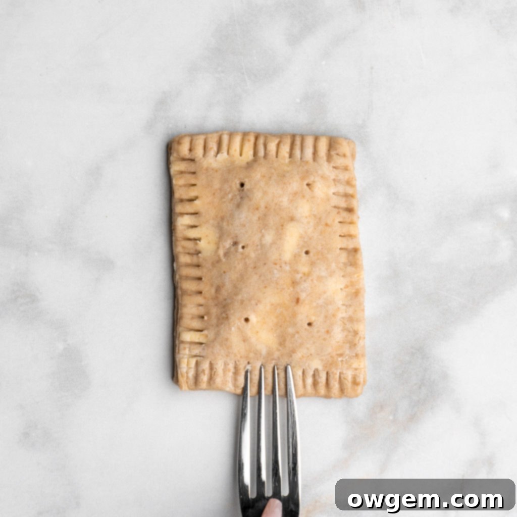 Crimp the edges of the S'mores Hand Pies with a fork for a decorative and secure seal.