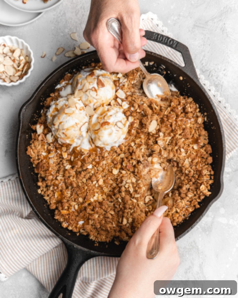 A close-up of a Maple Cardamom Apple Crisp showing the golden topping and bubbling apple filling, ready to be served.