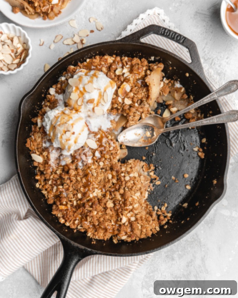 A freshly baked Maple Cardamom Apple Crisp, golden brown and bubbling, ready to be served from a baking dish.
