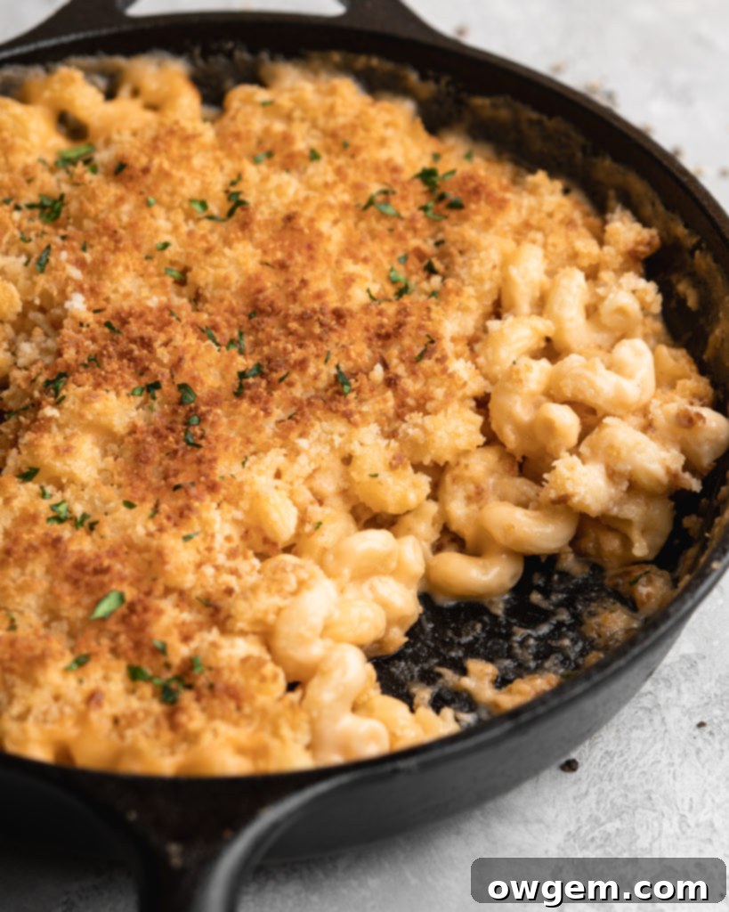 Close-up of baked beer mac and cheese with a golden, crispy topping and melted cheese, made with gruyere, mozzarella, cheddar, and beer.