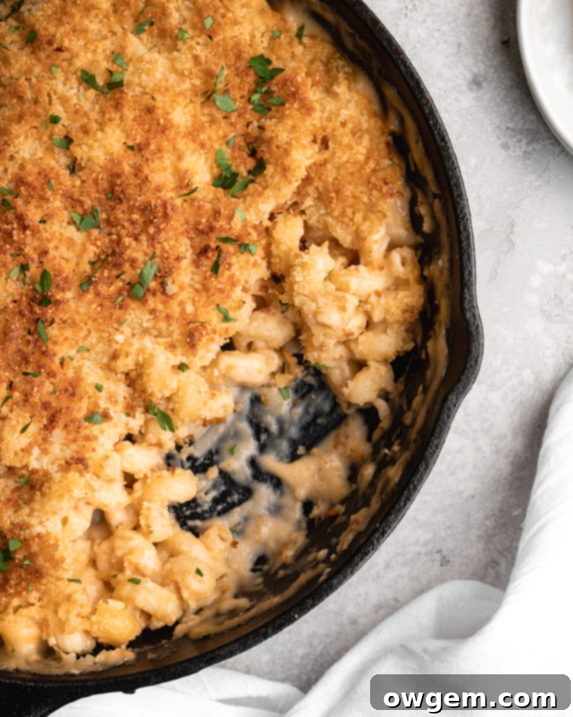 Delicious baked beer mac and cheese in a cast iron skillet, with a perfect golden crust.