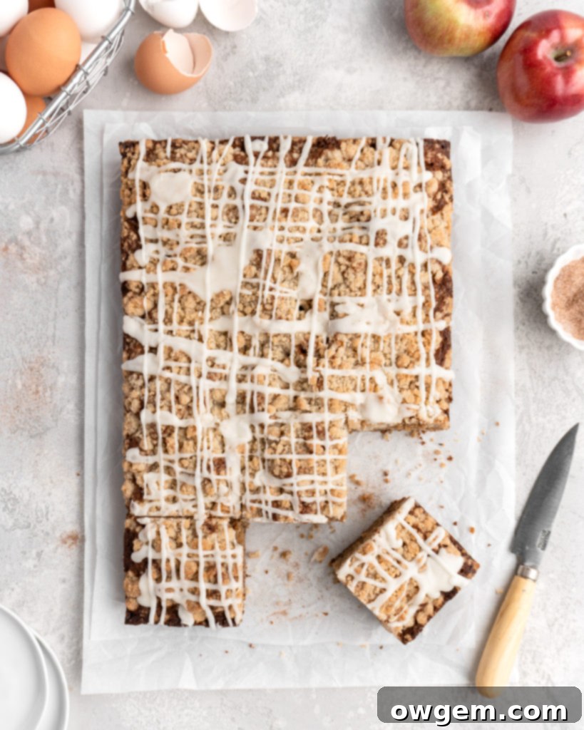 A slice of Apple Cinnamon Spice Cake on a plate, highlighting the tender cake, apple chunks, and crunchy streusel layer, ready to be glazed