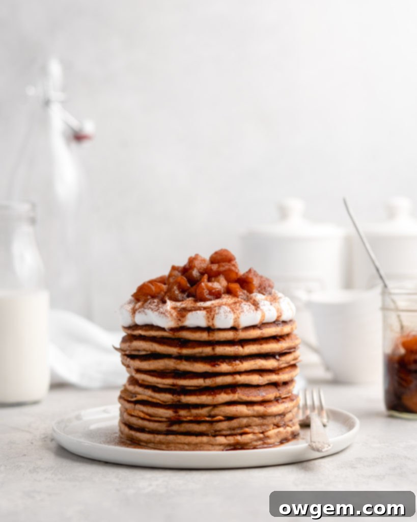 Close-up of fluffy apple cinnamon pancakes with homemade apple compote, showcasing the tender apples and rich syrup