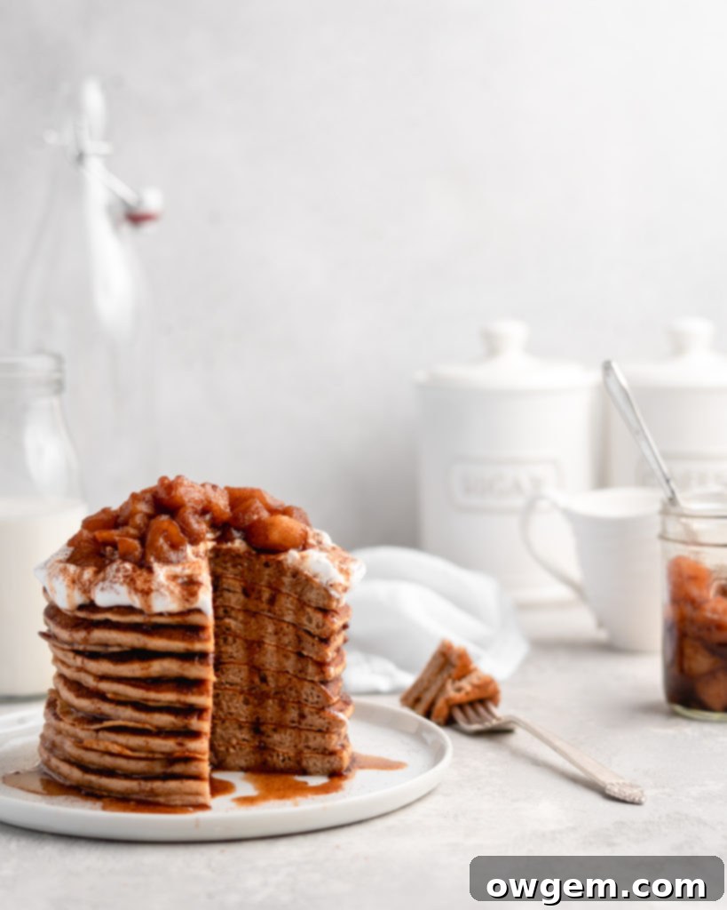 Homemade apple compote bubbling gently in a saucepan, with tender apple pieces and rich spiced syrup