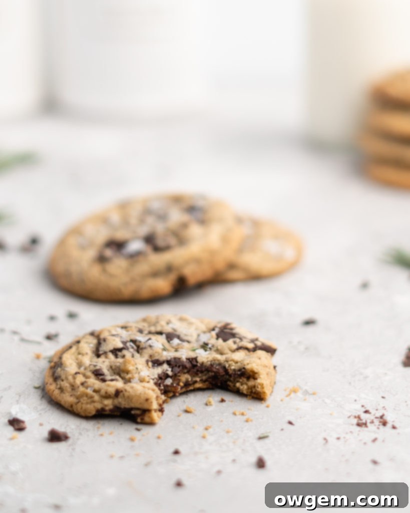 Scooped Rosemary Chocolate Chunk Cookies dough resting on a parchment-lined baking sheet before baking.