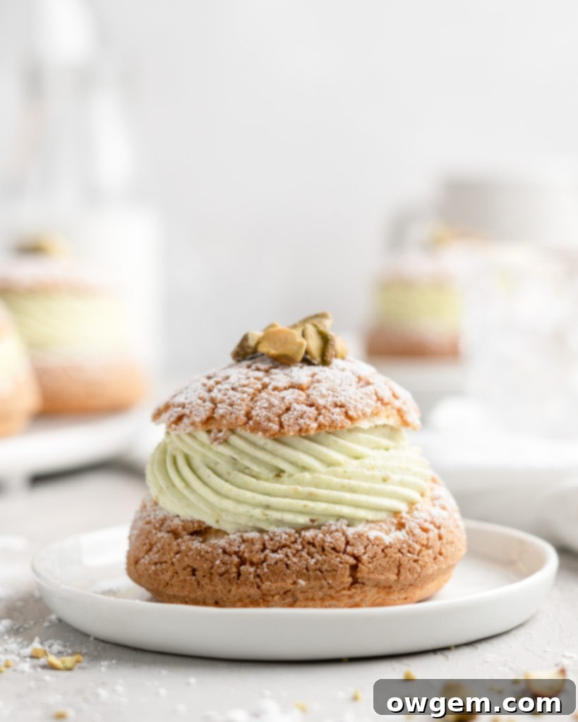 Cream Puff with craquelin topping, filled with a thick piped layer of whipped pistachio white chocolate ganache