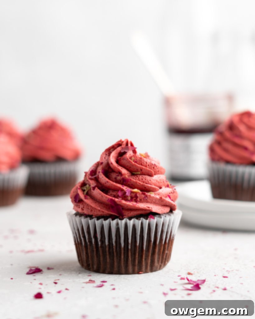 Fudgy chocolate cupcakes are filled with sweet cherry jam and topped with a cherry rosewater frosting, perfect for a romantic dessert