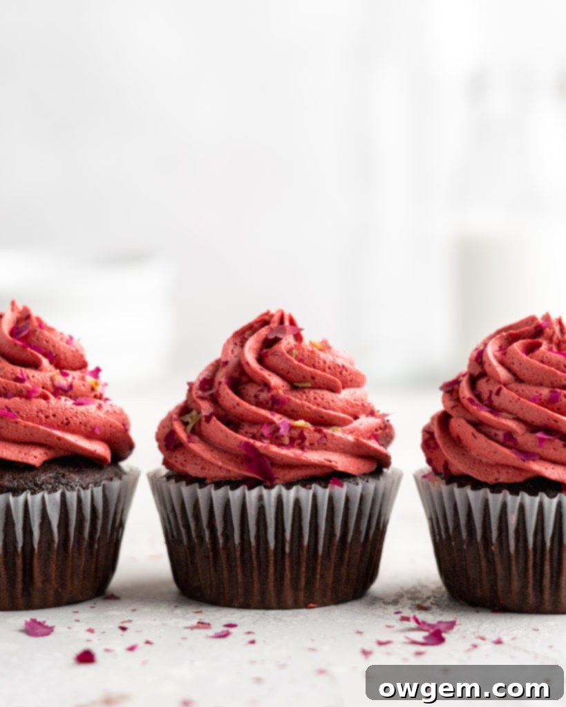Close-up of a fudgy chocolate cupcake filled with cherry jam and topped with cherry rosewater frosting, ideal for Valentine's Day