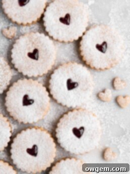 Linzer Cookies dusted with confectioners sugar and filled with raspberry jam