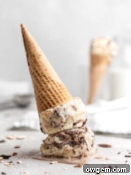 No churn almond ice cream is infused with a mocha swirl and full of chopped almonds, scooped into a cone