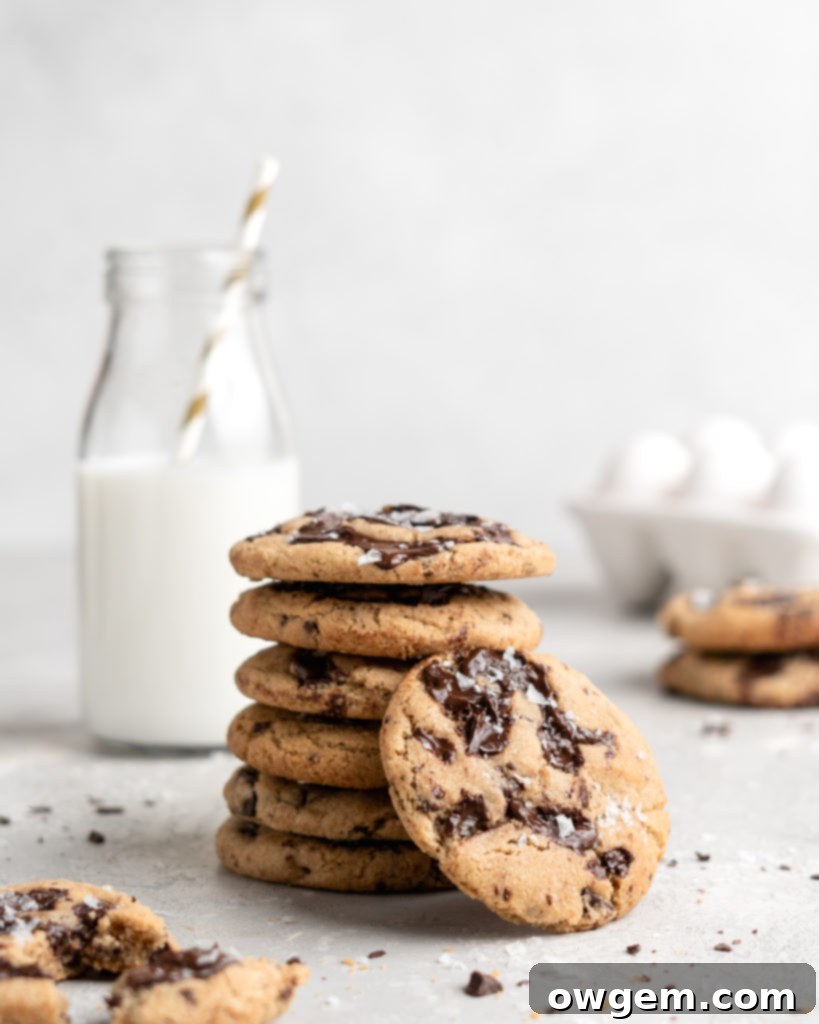 A stack of golden brown butter chocolate chip cookies, rich with melted chocolate, ready to be enjoyed.
