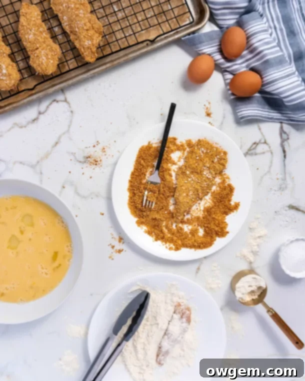 Two plates of perfectly baked, golden-brown chicken strips, ready to be served.