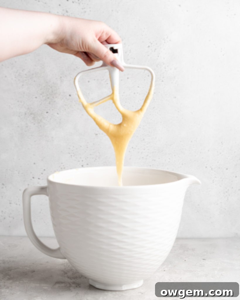 Close-up of choux pastry batter demonstrating the perfect 'V' shape consistency on a paddle attachment