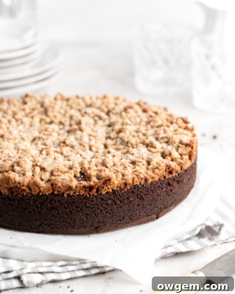 A close-up of a perfectly baked slice of Chocolate Toffee Crunch Cake on a white plate, showing the layers.