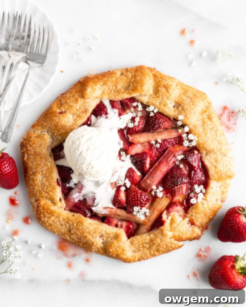 Flaky golden pie dough is folded into a galette shape over a strawberry rhubarb filling