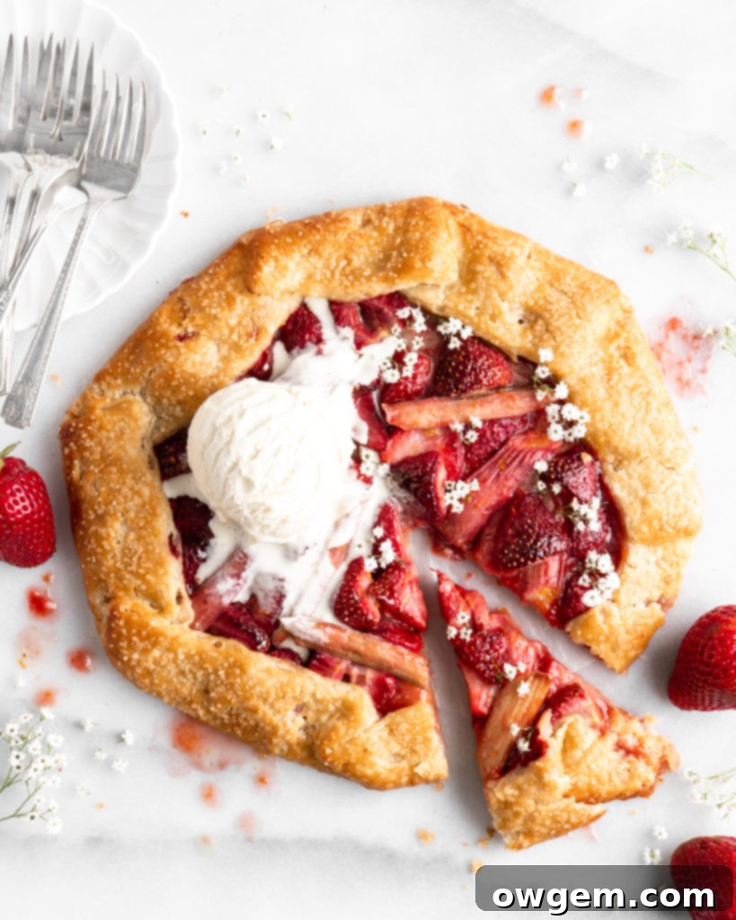 Flaky golden pie dough is folded into a galette shape over a strawberry rhubarb filling