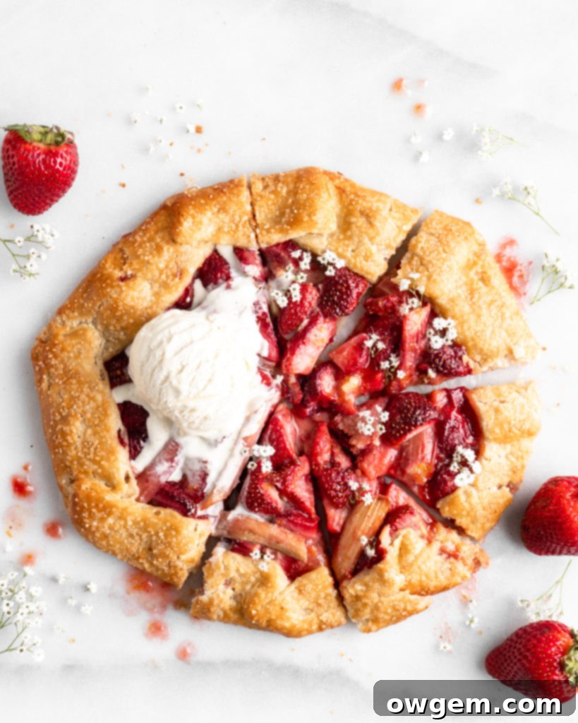 Flaky golden pie dough is folded into a galette shape over a strawberry rhubarb filling