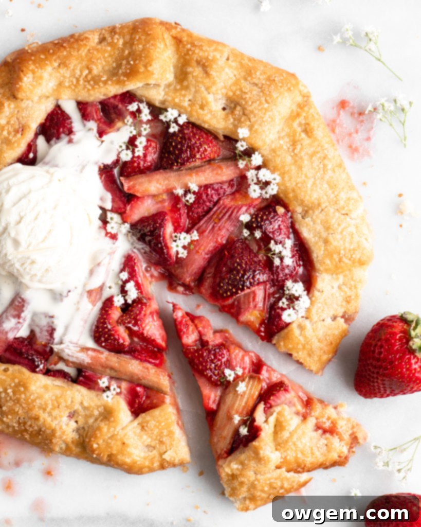 Flaky golden pie dough is folded into a galette shape over a strawberry rhubarb filling