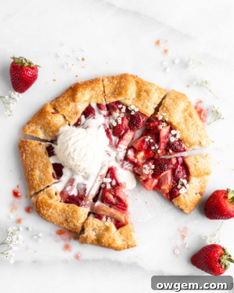 Flaky golden pie dough is folded into a galette shape over a strawberry rhubarb filling