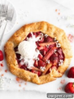 Flaky golden pie dough is folded into a galette shape over a strawberry rhubarb filling