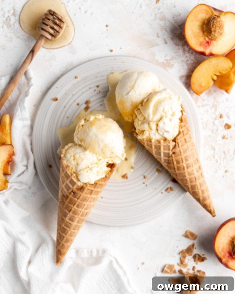 Two cones of homemade salted honey and peach no-churn ice cream ready to be served