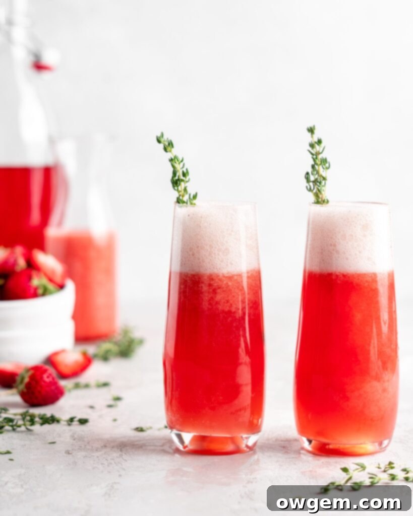 Bright red strawberry guava juice is mixed with sparkling rose wine in stemless champagne glasses to make Strawberry Guava Mimosa