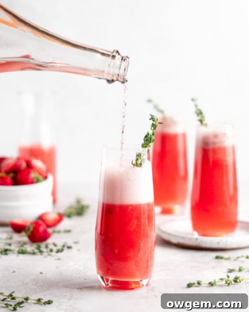 Bright red strawberry guava juice is mixed with sparkling rose wine in stemless champagne glasses to make Strawberry Guava Mimosa